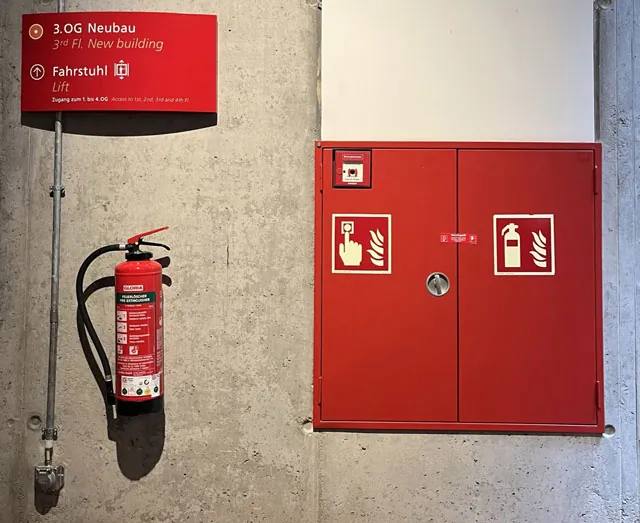 Brandmeldeanlagen und Feuerlöscher auf grauer Betonwand