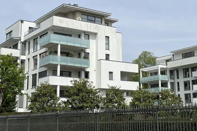 Zutrittskontrollsysteme - modernes Wohngebäude abgesichert durch einen Zaun